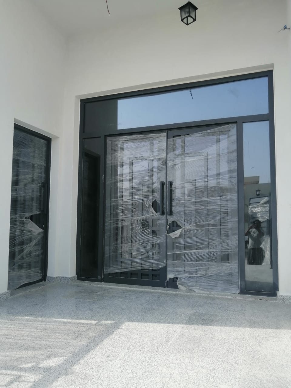 Glazed steel entrance door with sidelights at a villa