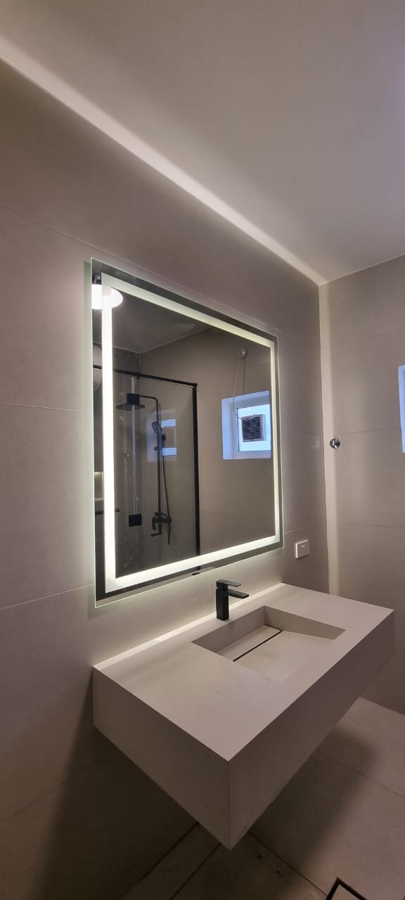 Floating vanity with backlit mirror.