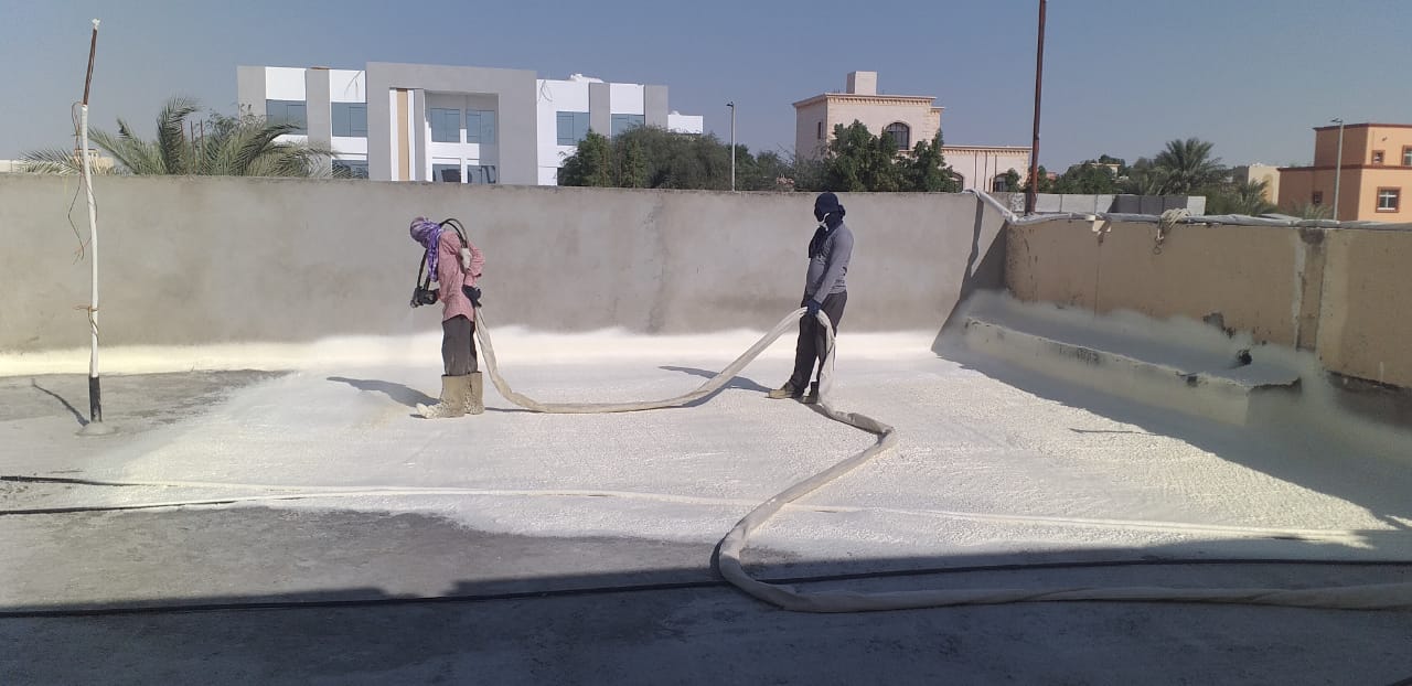 Build Marque crew spray-applying a roof waterproofing system.